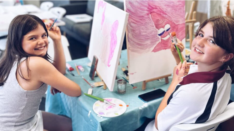 Two young people mid painting art project at the Aspendale Youth Cove.